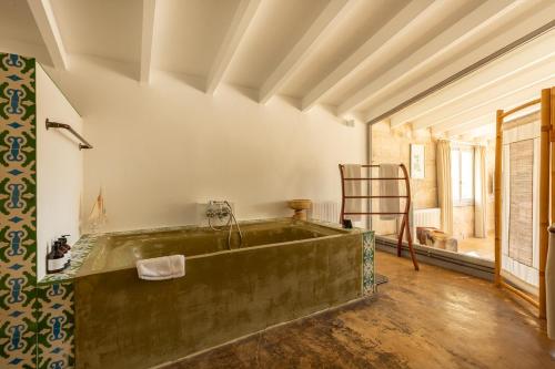 an old bath tub in a room with a chair at Finca Amapola - Agrotourismus in Campos
