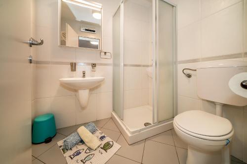 La salle de bains est pourvue de toilettes, d'une douche et d'un lavabo. dans l'établissement Apartment Jelka 2, à Krk
