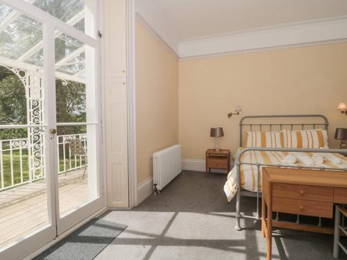 een slaapkamer met een bed, een bureau en een raam bij The Westgate in Bridport