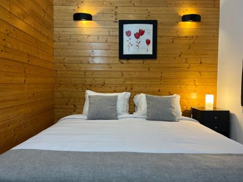 エリセイラにあるCoxos Beach Lodgeの白いベッド1台が備わる木製の壁のベッドルーム1室