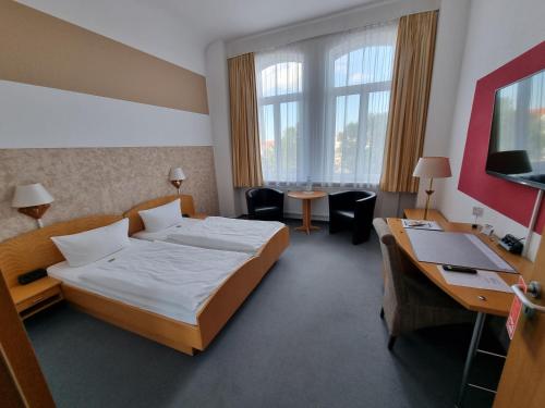 a hotel room with a bed and a desk at Hotel Zur Alten Druckerei in Gotha