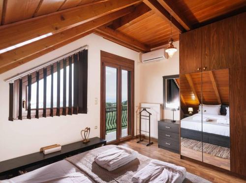a large bedroom with a bed and a balcony at Myron Olive Villa Retreat in Áyios Míron