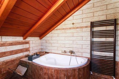a large bath tub in a room with a wooden ceiling at Myron Olive Villa Retreat in Áyios Míron