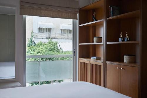 a bedroom with a bed and a large window at Chic designer home next - Hilton in Athens