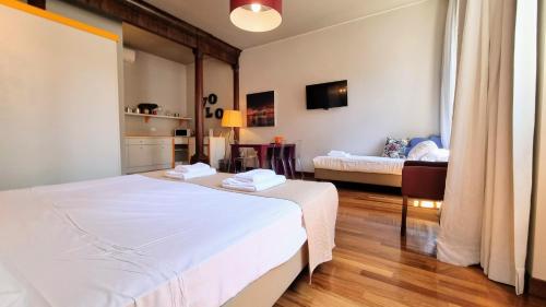 a bedroom with two beds and a living room at Locanda Al Volo Tommaseo in Trieste