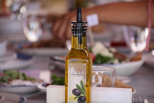 a bottle of olive oil sitting on a table with a glass at Buyuk Truva Hotel in Canakkale