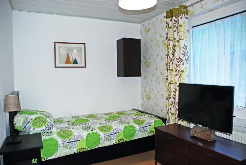 a bedroom with a bed and a flat screen tv at Waldblick Landhaus B&B in Schwarzenbach an der Pielach