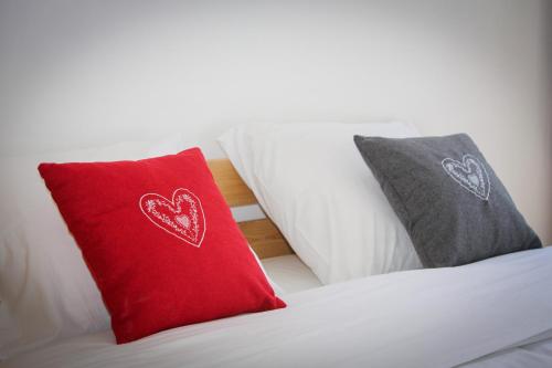 a red pillow and two gray pillows on a bed at Superbe T3 en face du Brevent, Chamonix in Chamonix-Mont-Blanc