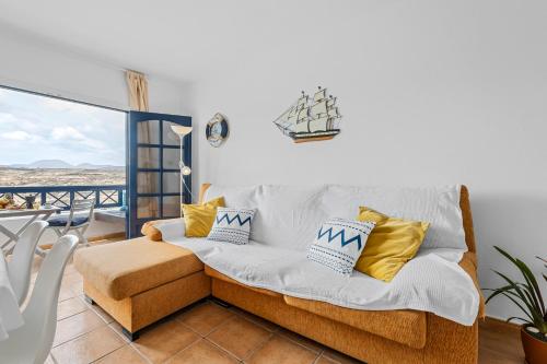 sala de estar con sofá y balcón en Home2Book Charming Apt Caleta de Caballo Beach, en Caleta de Caballo
