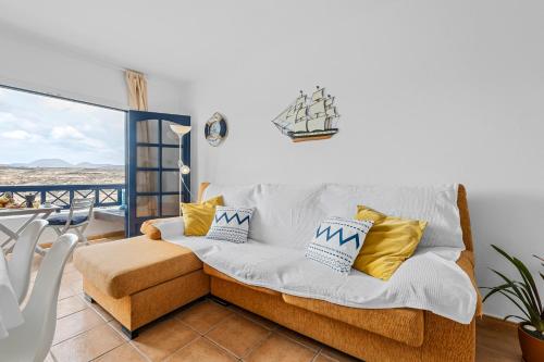 a living room with a couch and a balcony at Home2Book Charming Apt Caleta de Caballo Beach in Caleta de Caballo