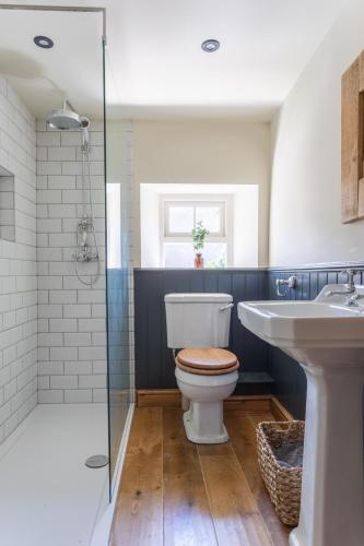 a bathroom with a toilet and a sink and a shower at Chapel Cottage with Log Burner (Dog Friendly) in Hawes
