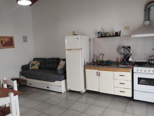 uma cozinha com um frigorífico e um sofá. em Alquilo depto 1 dorm en Zárate em Zárate