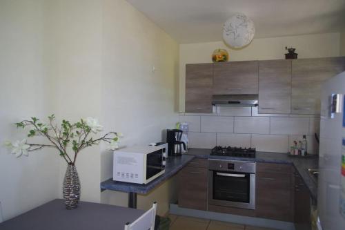 a kitchen with stainless steel appliances and a clock on the wall at LE BIGARADIER in Sainte-Rose