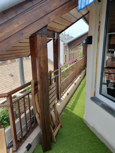 a balcony with a wooden railing and green grass at Modern top floor loft with balcony in Budapest
