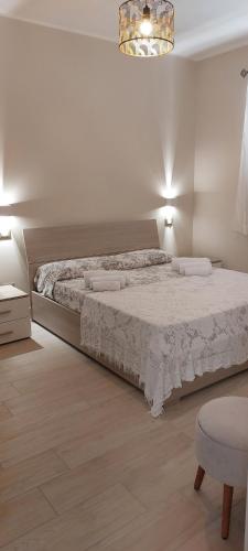 Un dormitorio con una cama grande y una silla. en Casa vacanze Sabbie di Giove, en Patti