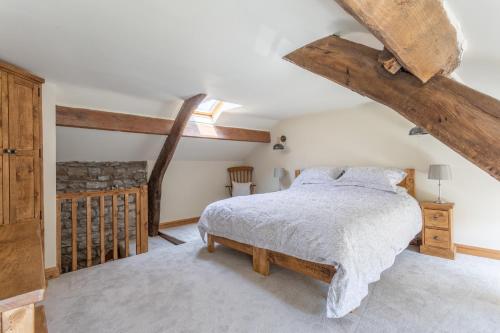 a bedroom with a bed and wooden beams at Chapel Cottage with Log Burner (Dog Friendly) in Hawes