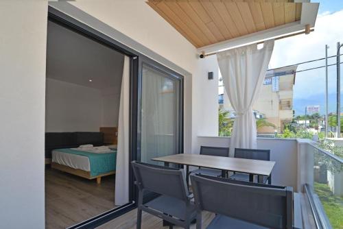 a balcony with a table and chairs and a bedroom at Anassa Suites in Leptokaria