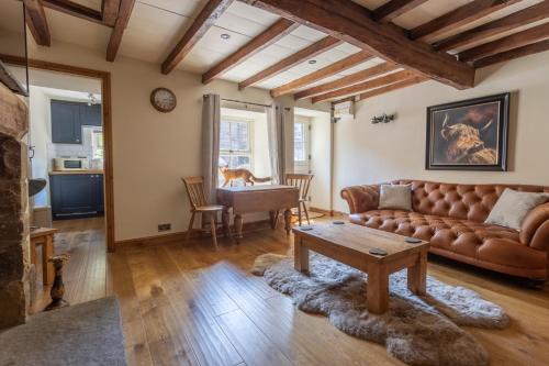 een woonkamer met een bank en een tafel bij Chapel Cottage with Log Burner (Dog Friendly) in Hawes