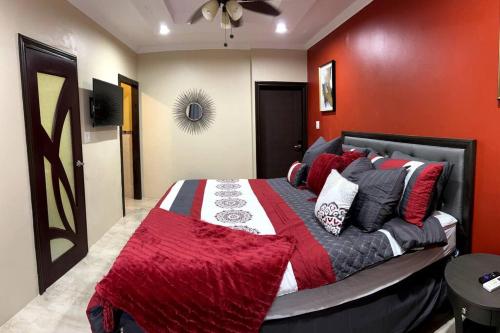 a bedroom with a large bed with red walls at Spacious 4-Bedroom Home - Family/Group Oriented in Harbour View