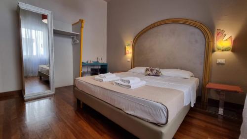 a bedroom with a large bed with two towels on it at Locanda Al Volo Tommaseo in Trieste