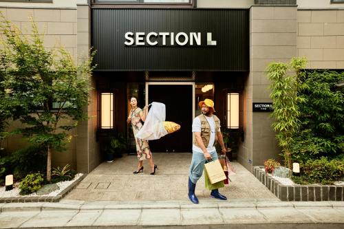 two people walking in front of a fashion store at Section L Tsukiji in Tokyo