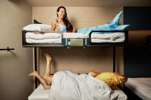 a woman sitting on top of two bunk beds at Section L Tsukiji in Tokyo
