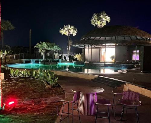 a building with chairs and a pool at night at V Hotels and Resorts in Chīrāla