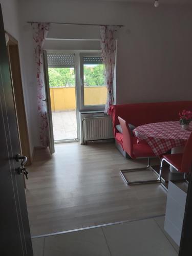- un salon avec un canapé rouge et une table dans l'établissement APARTMENTS KRAPEC3, à Ježdovec