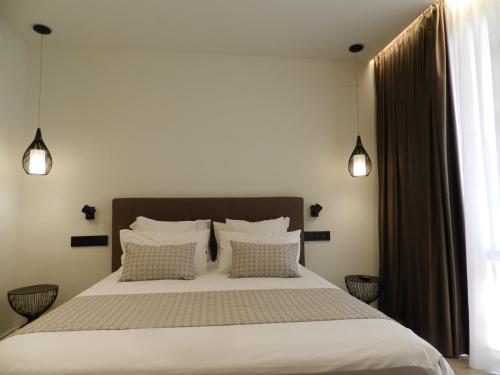 a bedroom with a large bed with two pillows at HOTEL MANEL in Martorell