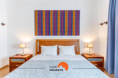 a bedroom with a bed with two night stands and two lamps at #056 Old Post Office by Home Holidays in Albufeira