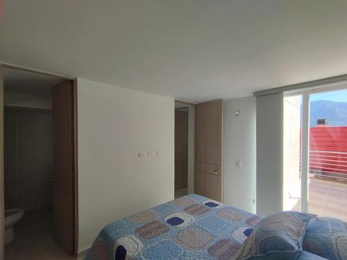 een slaapkamer met een bed en een groot raam bij Lindo Apartamento Ibagué-Tolima in Ibagué