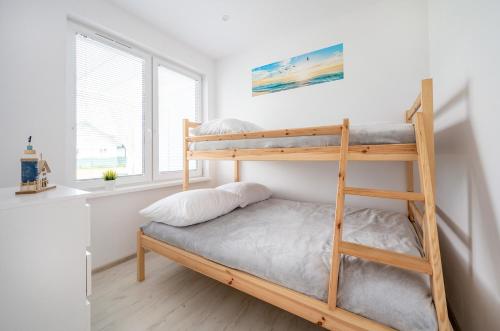 a bunk bed in a room with a ladder at Niebiańska Przystań Rusinowo in Rusinowo