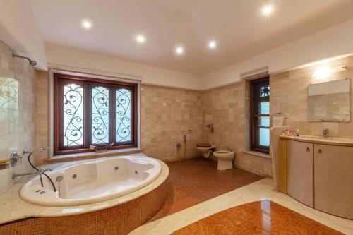 een grote badkamer met een bad en een toilet bij StayVista at Tranquil Bay- Exclusive getaway in Alibaug in Alibaug