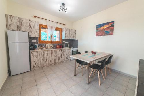 a kitchen with a table and chairs and a refrigerator at Pelion Charming Cottage, Panoramic Seaview Retreat in Volos