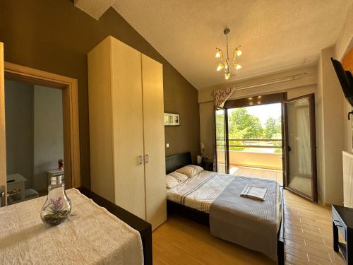 a hotel room with two beds and a balcony at Escape to Paradise Experience Luxury and Serenity at Villa Elina in Sithonia in Metókhion Ayías Kiriakís