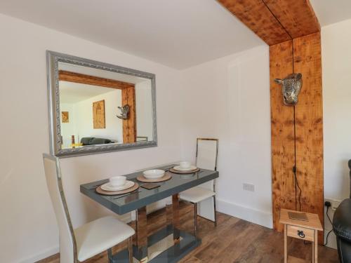 a dining room with a table and a mirror at Foxes Den in Ferndown