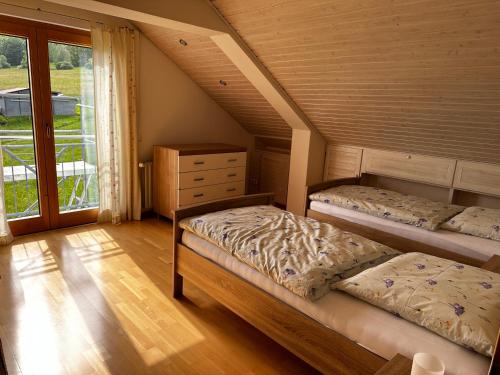 - une chambre mansardée avec 2 lits et une fenêtre dans l'établissement Ferienwohnung zum Lösershag, à Wildflecken