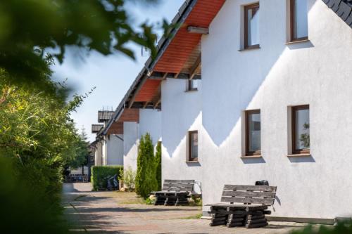 a group of benches in front of a building at Ośrodek Wypoczynkowy SWALLOW in Grzybowo