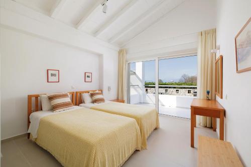 two beds in a white room with a window at Villa Levanda by WhiteDream Villas in Kassiopi