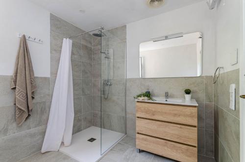 a bathroom with a shower and a sink and a mirror at YourHouse Can Marquesi in Lluc