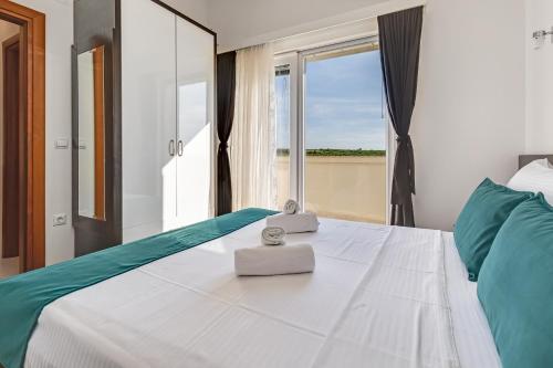 a bedroom with a large bed with a window at Apartman Strmota s bazenom i jakuzijem in Sveti Filip i Jakov