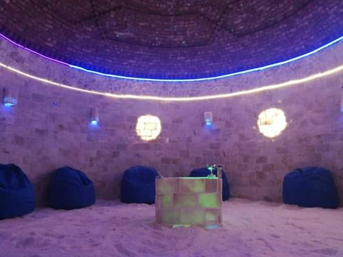 a room with a stage with blue lights and a suitcase at Panta Lodge Siwa بنتا لودج سيوة in Siwa