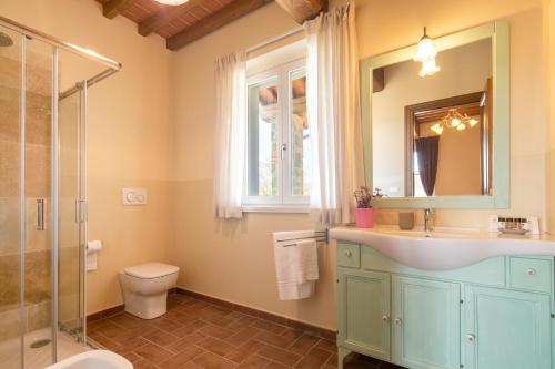 y baño con lavabo, aseo y espejo. en Casale la Querce by VacaVilla, en Civitella in Val di Chiana