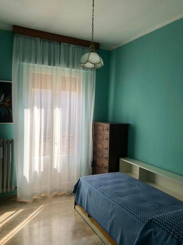 a bedroom with blue walls and a bed and a window at Casa elegante in centro a Paglieta in Paglieta