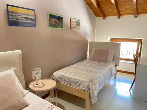 een kleine slaapkamer met 2 bedden en een tafel bij Dolce Dormire appartamento fiore in Negrar