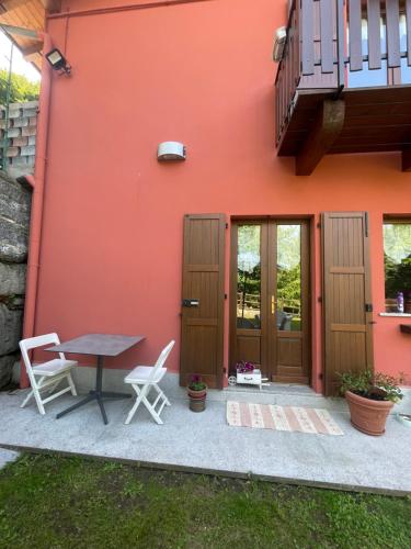 un patio exterior de una casa con mesa y sillas en Casa Iris, en Omegna