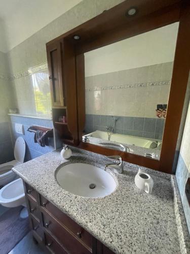 y baño con lavabo y espejo. en Casa Iris, en Omegna