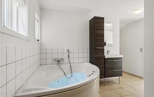 een badkamer met een ligbad en een wastafel bij Beautiful Home In Tarm With 3 Bedrooms, Sauna And Wifi in Hemmet
