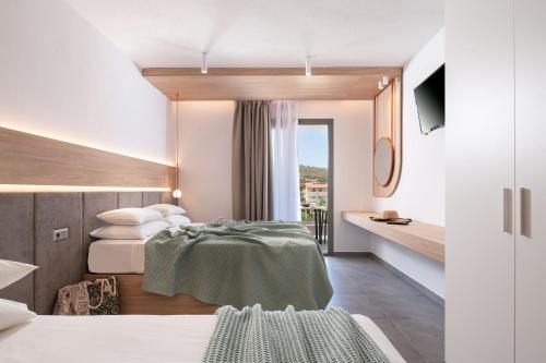 um quarto de hotel com duas camas e uma varanda em Asteras Hotel em Sarti