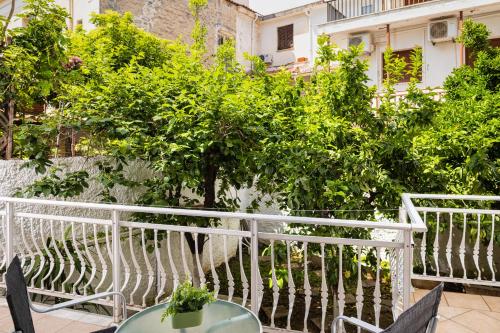 a balcony with a table and chairs and trees at Thetis Luxury Apartment in Samos